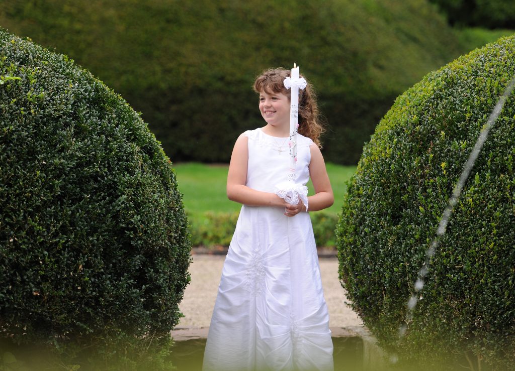 Klassisches Kommunionbild von Mädchen mit Kerze