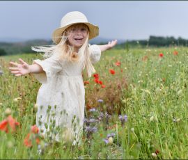Kinderfotos in der Natur - Kleines Mädchen in einer bunten Blumenwiese