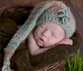 Neugeborenens Baby mit Mütze schlafend im Korb