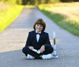 Kommunionkind im Anzug in der Natur